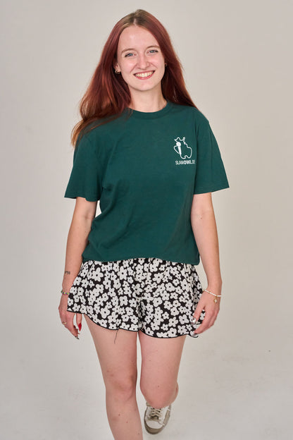 Eine junge Frau mit langen roten Haaren trägt das T-Shirt Poetry Slam - SLAM OWL - Logo & Eule - weiß auf Farbe | Bio-Qualität" von Artbookings/Shirtigo und verkörpert mit ihrem lässigen Selbstbewusstsein den lebendigen Geist der Poesie in Ostwestfalen-Lippe.