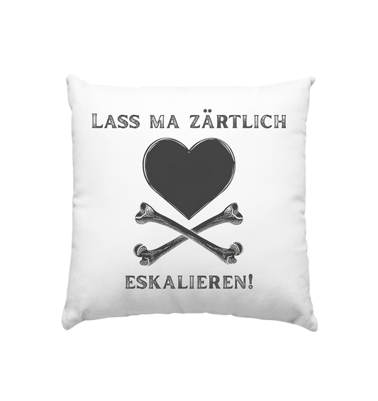 Weißes Kissen 40 x 40 cm mit schwarzem „Lass ma zärtlich eskalieren!“-Motiv, Herz und gekreuzten Knochen - Wohnaccessoire zur Krawall + Zärtlichkeit Poetry-Slam-Kollektion.