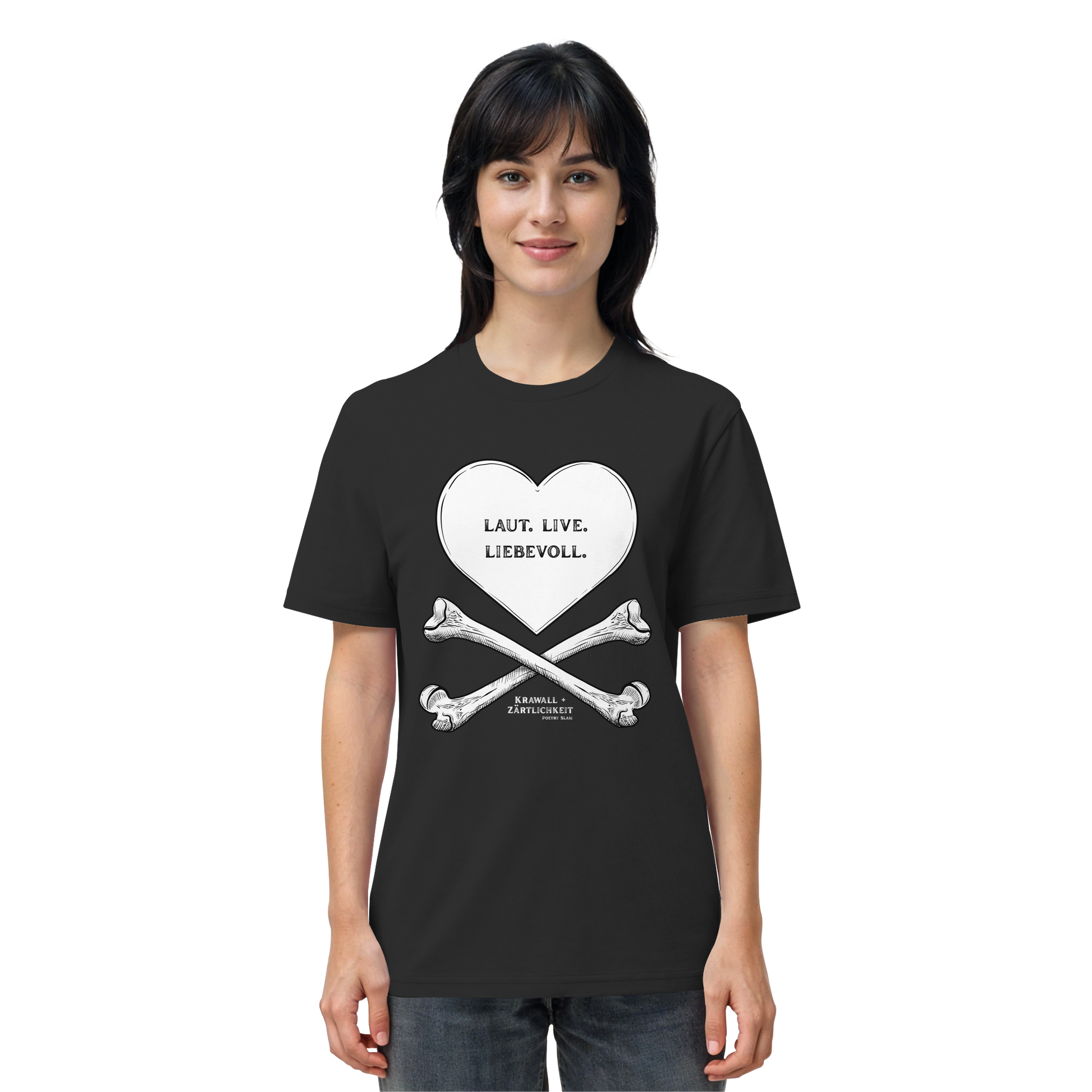 Eine Frau blickt mit einem leichten Lächeln nach vorne und trägt das Artbookings/Shirtigo-Statement-T-Shirt „Laut. Live. Liebevoll.“ (Weiß auf Schwarz). Das schwarze Shirt zeigt eine auffällige Grafik aus einem Herz und gekreuzten Knochen mit der Aufschrift „LAUT. LIEB. LIEBEVOLL.“ auf Deutsch – ein Motiv, das den Geist von „Krawall + Zärtlichkeit“ verkörpert, der bei Veranstaltungen wie dem Poetry Slam Essen beliebt ist.