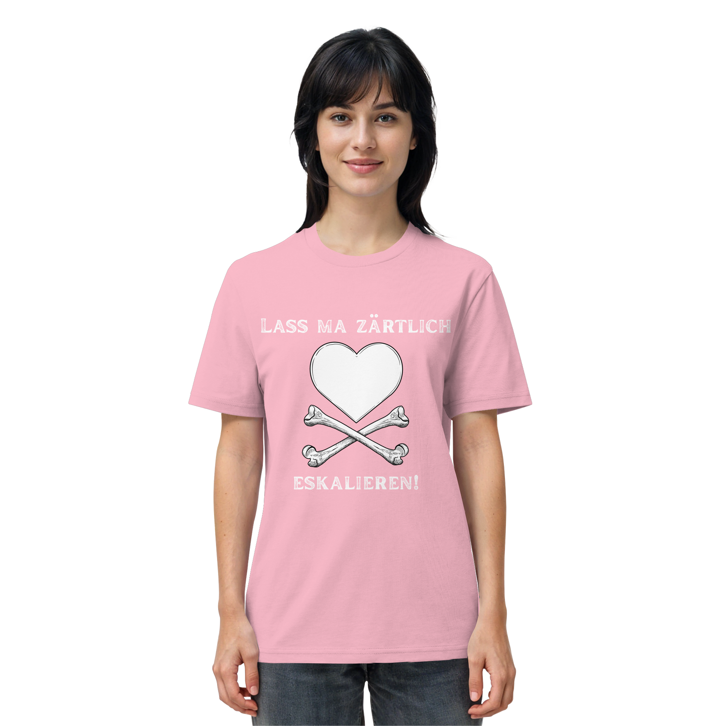 Eine Frau trägt das T-Shirt „Lass ma zärtlich eskalieren!“ von Artbookings/Shirtigo zum Poetry Slam „Krawall + Zärtlichkeit“ in Bio-Qualität, das mit einem rosa Motiv mit Herz, gekreuzten Knochen und einem deutschen Slogan bedruckt ist.
